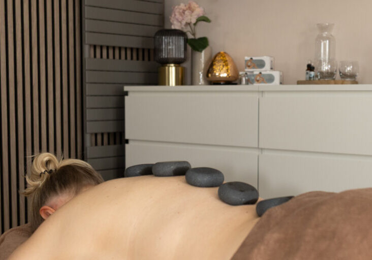 Hotstone massage in Apeldoorn met warme basaltstenen voor diepe ontspanning en het verminderen van spier- en stressklachten.
